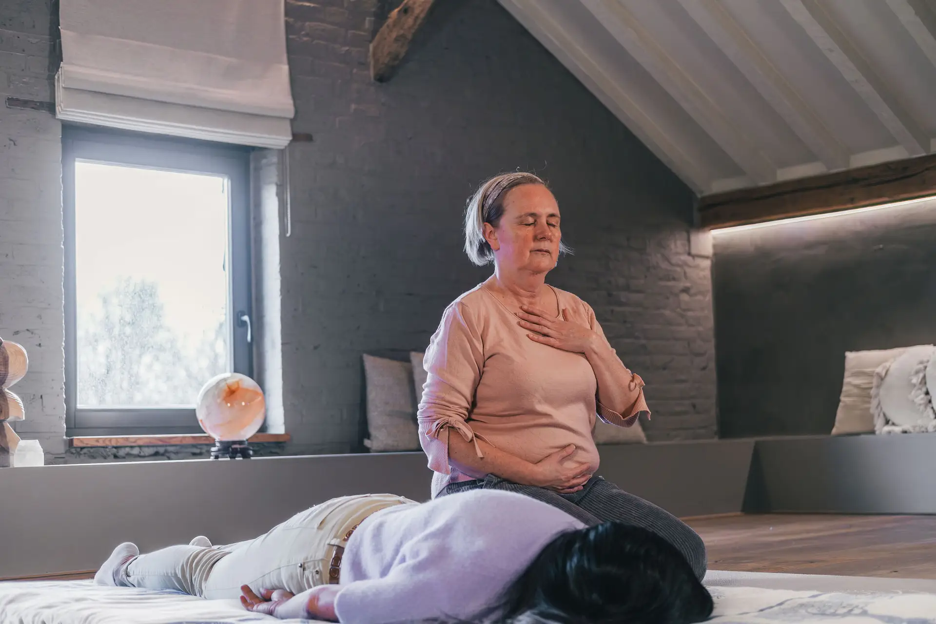 Anja Van Damme naast een cliënte tijdens een behandeling