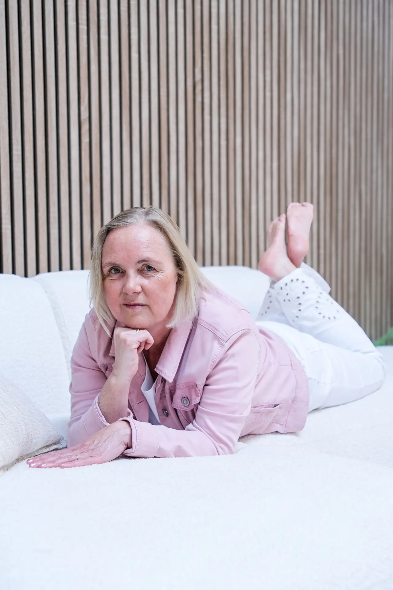Anja Van Damme ligt ontspannen op een bed